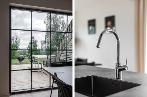 uma cozinha com um lavatório e vista para um pátio em Villa Röd em Habo
