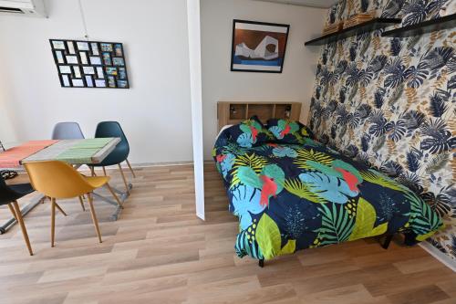 une chambre avec un lit, une table et des chaises dans l'établissement La Magnifique, à Mandelieu-la-Napoule