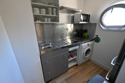 une petite cuisine avec un évier et une machine à laver dans l'établissement La Magnifique, à Mandelieu-la-Napoule