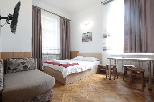 a bedroom with a bed and a chair and a window at Deluxe Apartments on Doroshenka 29 in Lviv
