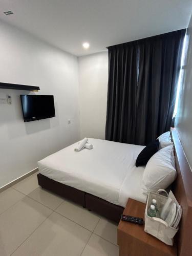 um quarto de hotel com uma cama e uma televisão em Pets and Family Guesthouse Kota Laksamana, Melaka em Malaca