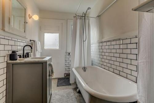 a white bathroom with a tub and a sink at Luxe Mid-Century Styled Historic Townhouse #1 in Detroit