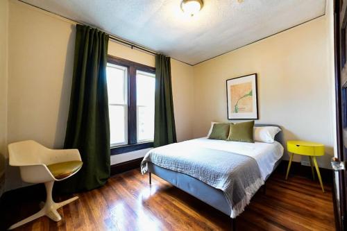 底特律的住宿－Luxe Mid-Century Styled Historic Townhouse #2，卧室配有床、椅子和窗户。