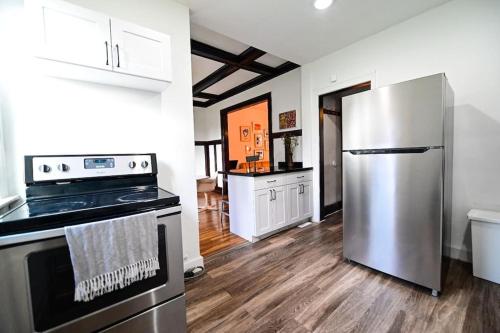 a kitchen with a stainless steel refrigerator and white cabinets at Luxe Mid-Century Styled Historic Townhouse #2 in Detroit