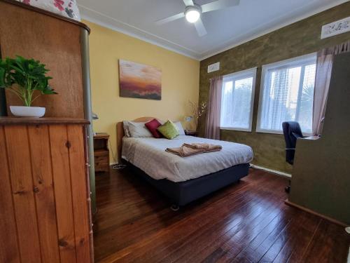 a bedroom with a bed and a dresser in it at Kurranulla Sapphire - Unit 1 in Cronulla