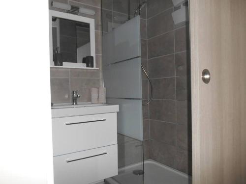 een badkamer met een witte wastafel en een douche bij T2 - Résidence Plein Sud in Cabourg