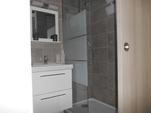 une salle de bain avec un lavabo blanc et une douche dans l'établissement T2 - Résidence Plein Sud, à Cabourg