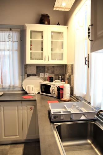 a kitchen with white cabinets and a sink at Symi . VILLA CALME (Sur la Mer). in Symi
