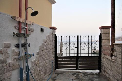 a black gate with a shower in front of a door at Symi . VILLA CALME (Sur la Mer). in Symi
