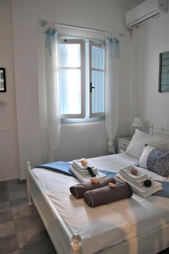 a bedroom with a bed with towels and a window at Symi . VILLA CALME (Sur la Mer). in Symi