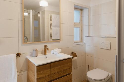 a white bathroom with a sink and a toilet at Ferienwohnung Weidenbach in Weidenbach