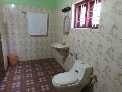 a bathroom with a toilet and a sink at Spice Garden Farm house in Sultan Bathery