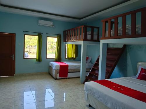 1 dormitorio con 2 literas y paredes azules en Hotel Benson en Cikembulan
