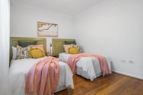 two beds sitting next to each other in a room at Stunning 2BR CBD Apartment next to King's Park in Perth