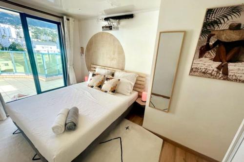małą sypialnię z łóżkiem i lustrem w obiekcie L appart dans les Nuages - Climatisé - Piscine - Vues panoramiques - Proche aéroport et Université w mieście Sainte-Clotilde