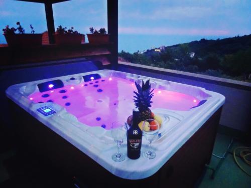 una bañera de hidromasaje con 2 copas de vino y una piña. en Apartments Tati, en Ulcinj