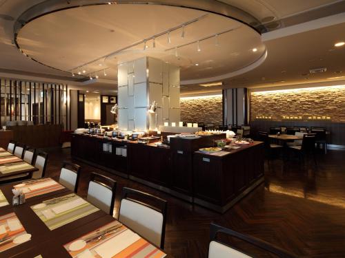 a restaurant with tables and chairs and a bar at Kichijoji Tokyu REI Hotel in Musashino