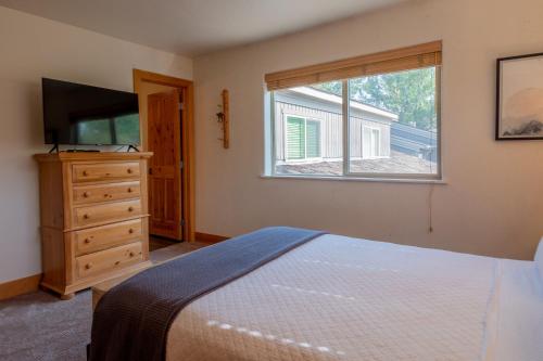 ein Schlafzimmer mit einem Bett, einem Fenster und einer Kommode in der Unterkunft Bridgepoint Condo 08 in Ketchum