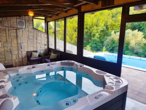 a large bath tub in a room with a pool at Challet Bella in Poljanica Bistranska