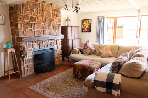 a living room with a couch and a fireplace at Mountain View Cottage in Dullstroom