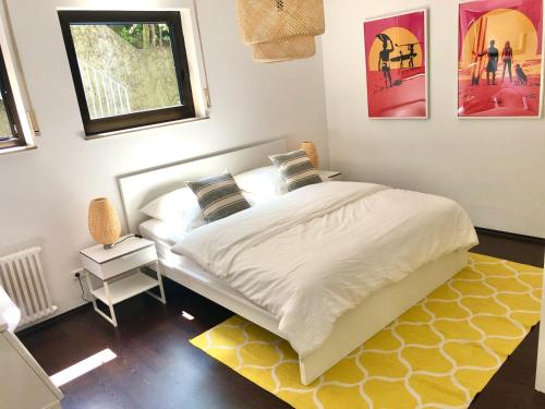1 dormitorio con cama blanca y alfombra amarilla en ☆ Zentrales Appartement mit traumhaftem Panorama ☆, en Winnenden