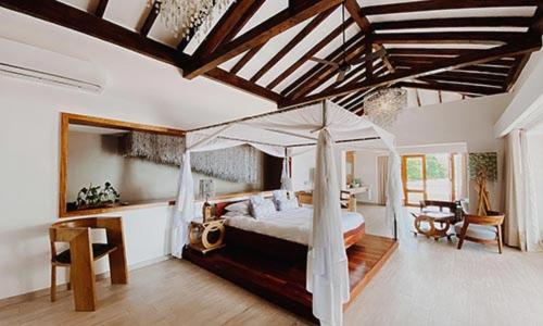 1 dormitorio con 1 cama con sombrilla en The Makokola Retreat en Mangochi