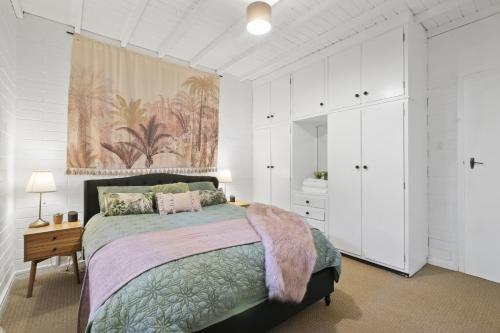 Henley Beach SouthGolden Sands的一间带大床和白色橱柜的卧室