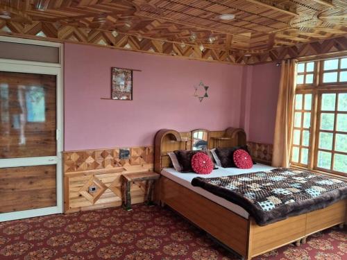 um quarto com uma grande cama de madeira com almofadas vermelhas em Cozee Mozee Family Homestay em Kufri