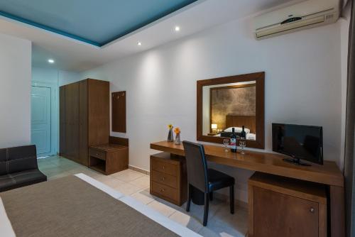 a room with a desk with a television and a chair at Gaia Village in Tigaki
