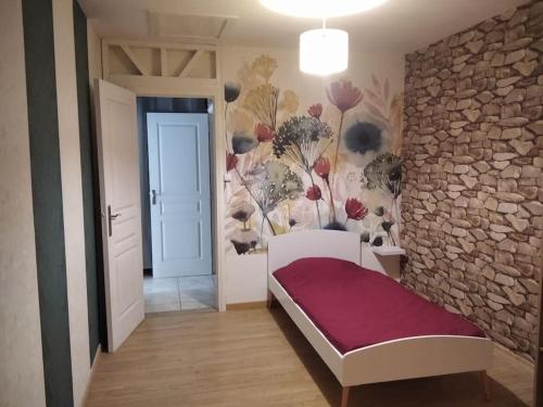 a bedroom with a stone wall and a bed in a room at La Tanière des Pandas in Chabris