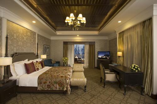 a hotel room with a bed and a desk and a bedroom at The Khyber Himalayan Resort & Spa in Gulmarg