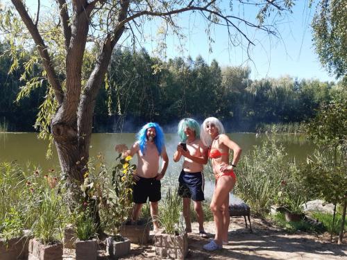 tres personas con el pelo azul de pie en frente de un lago en Letnia Rezydencja Roztocze, en Tomaszów Lubelski