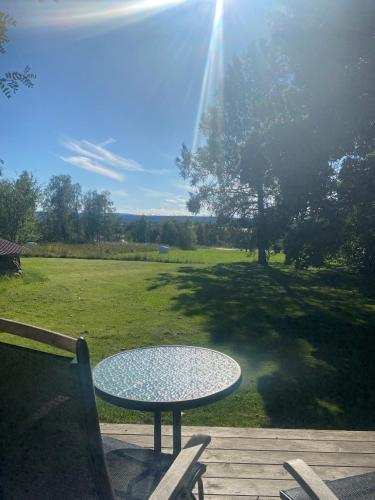 a table and chairs sitting on a deck with a view of a field at Villa Gasabäck in Söråker