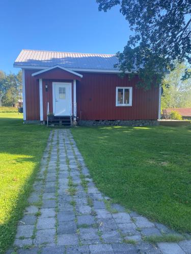 a red house with a white door and a grass yard at Villa Gasabäck in Söråker