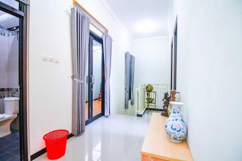 einen Flur mit einer Vase auf einem Tisch in der Unterkunft Harsari Syariah with Karaoke and Balcony in Batu