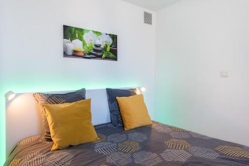 une chambre avec un lit avec des oreillers jaunes dans l'établissement Beautiful renovated studio with view- Old Hyères, à Hyères
