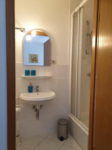 a white bathroom with a sink and a shower at Kottmarschenke - Gästezimmer und Ferienwohnung am Kottmar in Kottmar