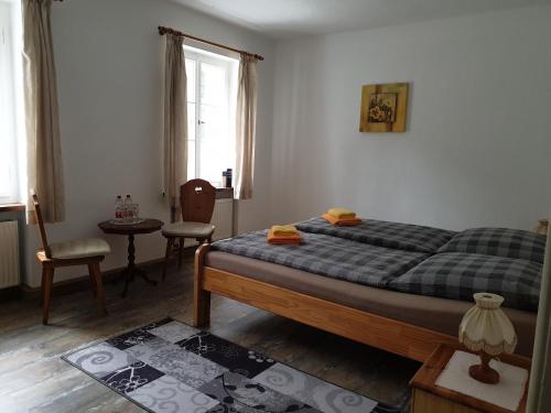 a bedroom with a bed and a table and a chair at Kottmarschenke - Gästezimmer und Ferienwohnung am Kottmar in Kottmar
