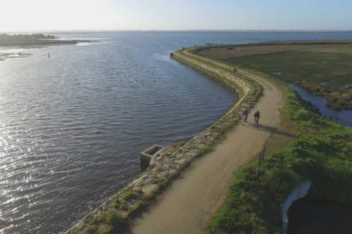 a person walking on a beach next to the water at Maison proche de la mer in Murtosa