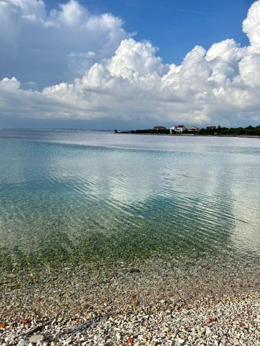 a large body of water with a rocky beach at Villa Runčika Luxury Apartment in Lukoran