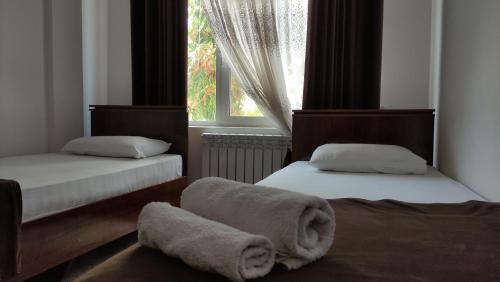 a bedroom with two beds with towels on the floor at Safiya hotel in Urganch