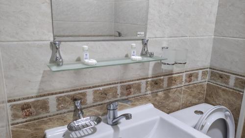 y baño con lavabo, aseo y espejo. en Safiya hotel, en Urganch