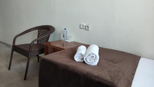a bedroom with two towels on a bed with a chair at Safiya hostel in Urganch