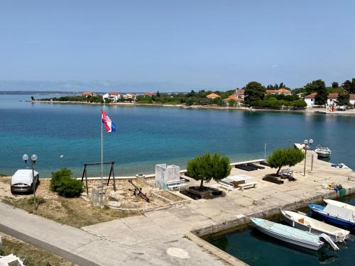 a view of a lake with boats and a flag at Villa Runčika Luxury Apartment in Lukoran