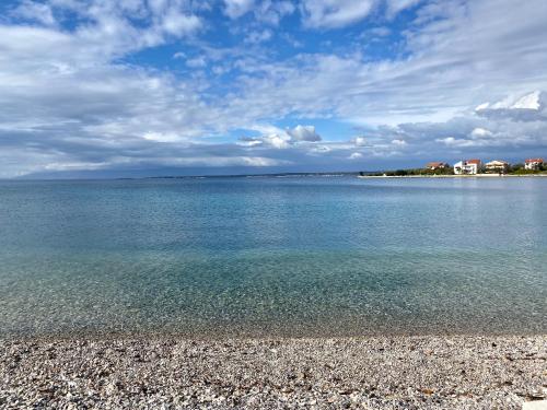 a large body of water with a rocky beach at Villa Runčika Luxury Apartment in Lukoran