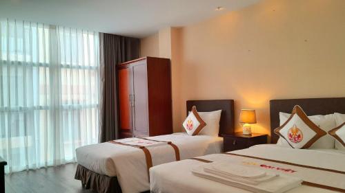 Habitación de hotel con 2 camas y ventana en THE RICE HOTEL en Ho Chi Minh