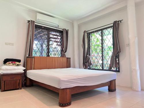 a bedroom with a bed and two windows at Tropical Garden-04-G in Nadi
