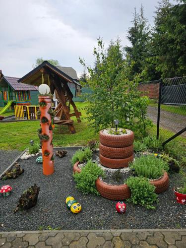 a garden with a tree and a pile of tires at Cabana Refugiul Montan Belis in Beliş