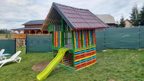 a colorful play house with a slide in a yard at Cabana Refugiul Montan Belis in Beliş