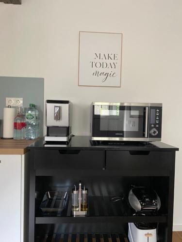 a microwave sitting on top of a black counter at Scheunentraum Brenig in Bornheim